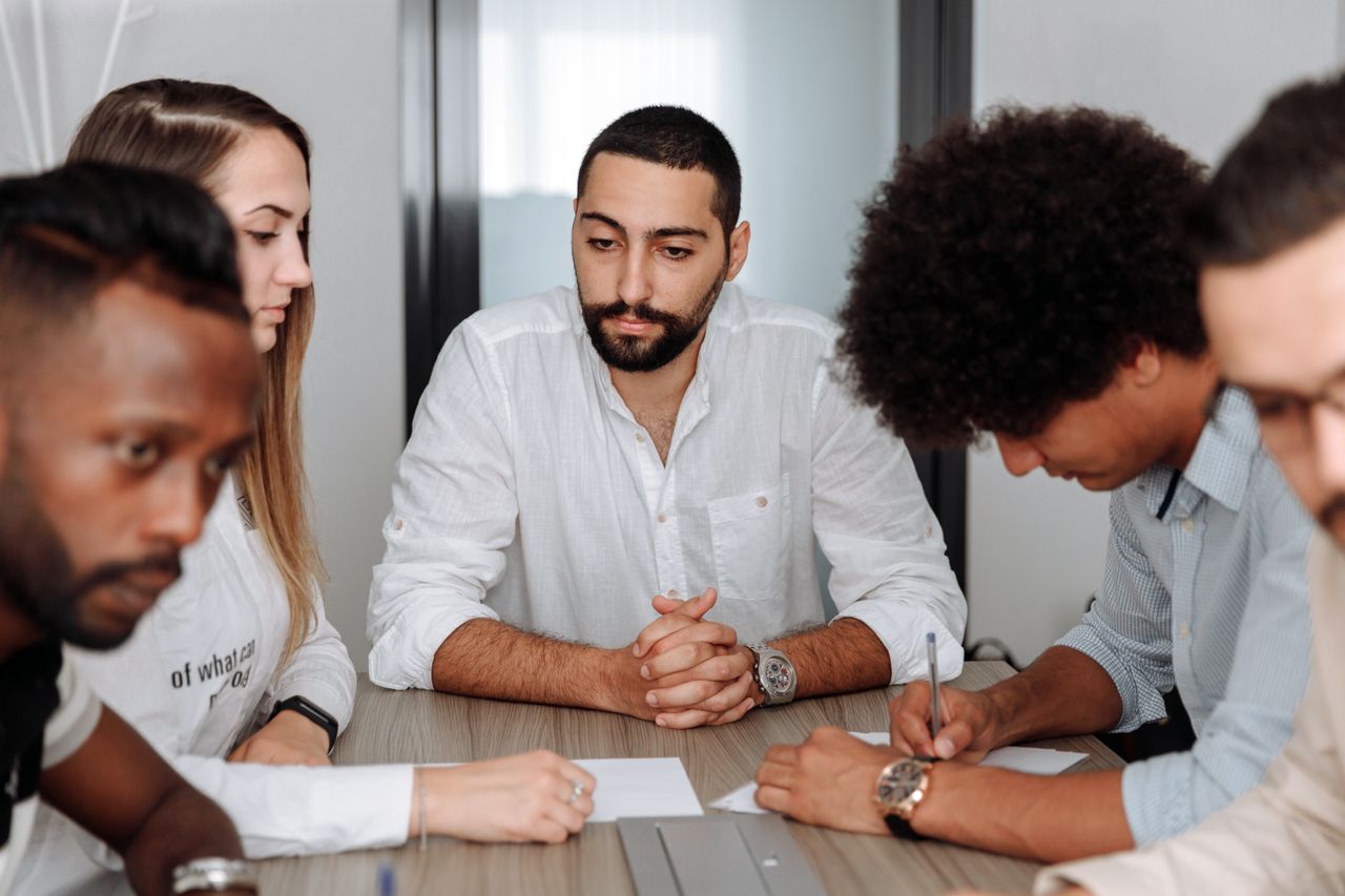 Mastering the First Impression: Your intriguing post title goes here A diverse team of adults collaborating in an office meeting, showcasing teamwork and professionalism.