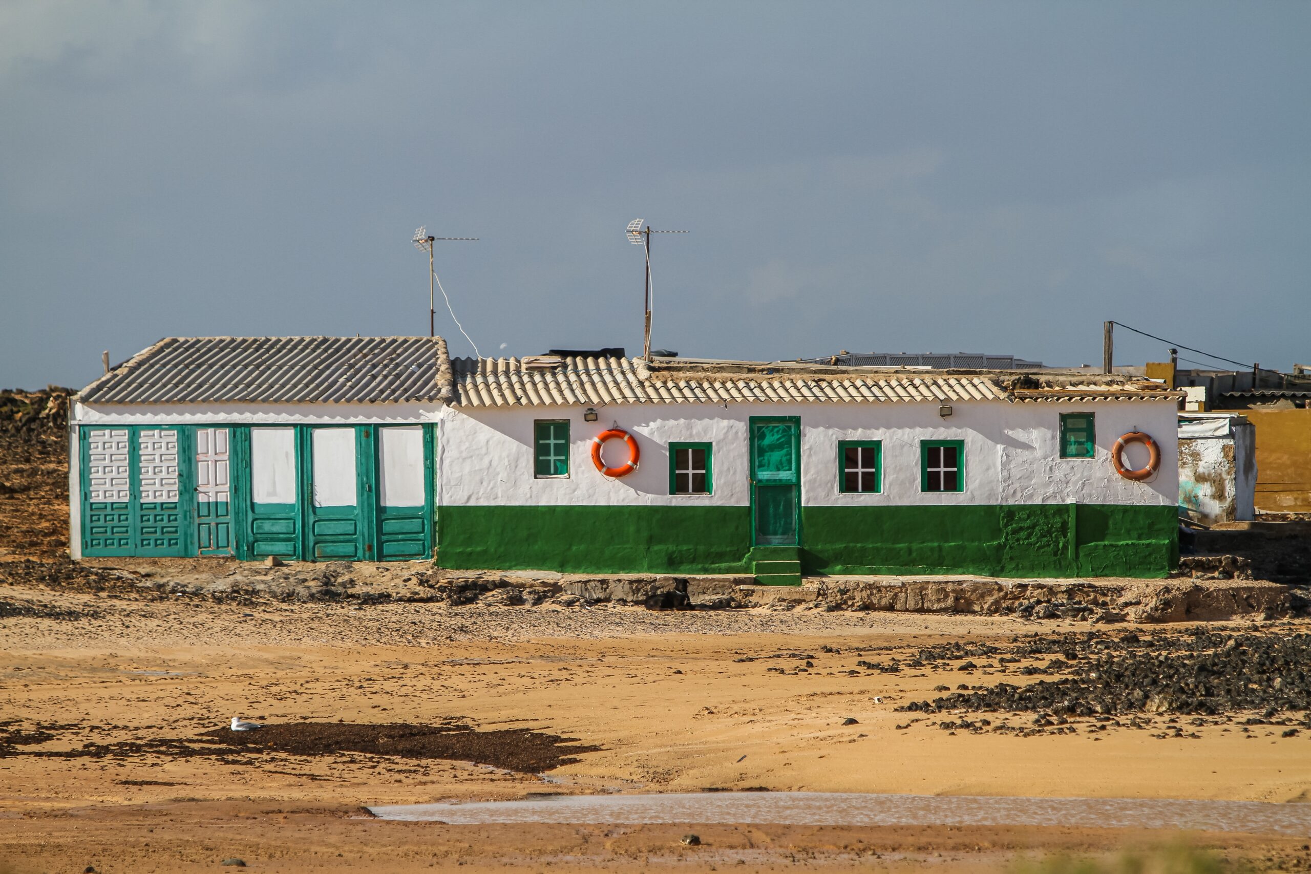 A white and green building in the middle of a field